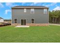 View of home's back elevation, showcasing a patio and grassy yard at 1601 Fuma Leaf Way, Mcdonough, GA 30253