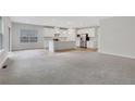 Open concept living room and kitchen with light gray walls and wood flooring at 1057 Climbing Rose Way, Mcdonough, GA 30253