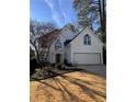 Elegant two-story home with a well-manicured lawn, attached garage, and striking architectural details at 4086 Haverhill Dr, Atlanta, GA 30342