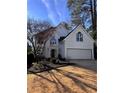 Elegant two-story home with a well-manicured lawn, attached garage, and striking architectural details at 4086 Haverhill Dr, Atlanta, GA 30342