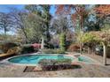 Inviting backyard pool featuring stone paving, lush landscaping and shaded areas for relaxation and entertainment at 4086 Haverhill Dr, Atlanta, GA 30342