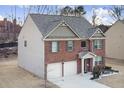 Two-story brick and beige home with a three-car garage at 3573 Stonebranch Ln, Loganville, GA 30052