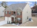 Elegant home featuring a brick facade, complementary siding, a two-car garage, and decorative landscaping in the front yard at 3573 Stonebranch Ln, Loganville, GA 30052