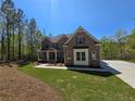 Charming brick two-story home with a covered front porch, green lawn, and a paved driveway leading to the property at 7449 Waterview Cv, Douglasville, GA 30135