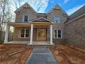 Inviting two-story brick home featuring a covered front porch with stone accents and a pathway leading to the entryway at 7449 Waterview Cv, Douglasville, GA 30135