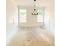 Bright dining room with wainscoting, two windows and a modern chandelier at 1275 Pj East Rd, Covington, GA 30014