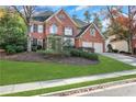 Two-story house with a brick facade, attached garage, and manicured lawn at 1215 Wynridge Xing, Alpharetta, GA 30005