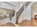 Elegant staircase with hardwood floors, carpeted steps, and decorative iron railings in a light and airy entryway at 1215 Wynridge Xing, Alpharetta, GA 30005