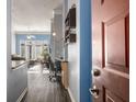 Hallway featuring dark floors, adjacent to the living room, an office nook, and a blue colored wall at 401 16Th Nw St # 1179, Atlanta, GA 30363