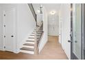 Bright entryway with hardwood floors, wooden staircase, and open floor plan at 89 Batten Board Way, Woodstock, GA 30189