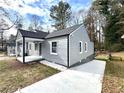 Gray sided home showcasing side yard, driveway and mature trees at 1271 Lorenzo Sw Dr, Atlanta, GA 30310