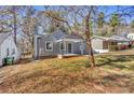 Charming gray house with a covered porch and mature trees in the front yard at 1271 Lorenzo Sw Dr, Atlanta, GA 30310