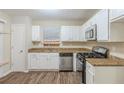 Bright kitchen featuring white cabinets, stainless steel appliances, granite countertops and wood-look flooring at 3950 Fennel Sw Cir, Atlanta, GA 30331
