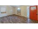 Bright living room with wood-look flooring, large windows, and a freshly painted orange entry door at 3950 Fennel Sw Cir, Atlanta, GA 30331