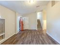 Inviting living room with wood-look floors, leading to a staircase and featuring a freshly painted entry door at 3950 Fennel Sw Cir, Atlanta, GA 30331