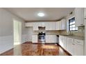 Renovated kitchen with white cabinets, granite counters, and hardwood floors at 2395 River Run Dr, Douglasville, GA 30135