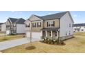 Two-story home with stone and siding accents, three-car garage, and manicured landscaping at 1029 Blue Juniper Cir, Loganville, GA 30052