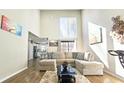 Spacious living room featuring a beige sectional sofa, large windows, and hardwood floors at 4485 Spring Valley Pkwy, Atlanta, GA 30349