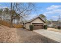 Side view of tan house with brown garage door and wooden fence at 546 Paden Dr, Lawrenceville, GA 30044