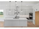 Modern kitchen with white cabinets, quartz countertops, and island at 6315 Wallace Farms Dr, Cumming, GA 30028