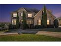Two-story brick home at dusk featuring manicured landscaping and a welcoming front entrance at 4851 Planters Walk, Douglasville, GA 30135