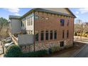 Side view of the townhome showcasing brick and stone exterior and private deck at 2022 Heathermere Way, Roswell, GA 30075