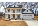 Two-story farmhouse with front porch, attached garage, and landscaped yard at 96 Rome St, Temple, GA 30179