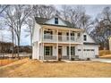 Two-story farmhouse with front porch, attached garage, and landscaped yard at 96 Rome St, Temple, GA 30179