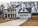 Two-story farmhouse with front porch, attached garage, and landscaped yard at 96 Rome St, Temple, GA 30179