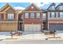 Brick front townhome with two-car garage and welcoming porch at 2429 Sardis Chase Ct, Buford, GA 30519