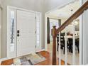 Bright entryway with hardwood floors, leading to dining room and staircase at 5220 Otter Creek Run, Cumming, GA 30040