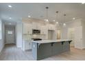 Modern kitchen with gray island, white cabinets, and stainless steel appliances at 746 Trevett Way, Marietta, GA 30062