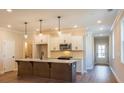 Open kitchen with stainless steel appliances, island, pendant lighting, and white cabinetry at 754 Trevett Way, Marietta, GA 30062