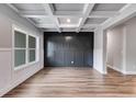 Dining room with dark gray wall paneling, hardwood floors, and a large window at 8920 Callaway Dr, Winston, GA 30187