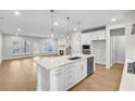 Open-concept kitchen with island, hardwood floors, and living room view at 134 Briargate Dr, Johns Creek, GA 30097