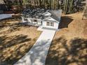 Newly built home with white siding, gray roof and a long driveway at 2716 Battle Sw Trl, Marietta, GA 30064