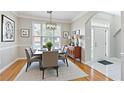 Inviting dining room with modern chandelier, wood floors, and plenty of natural light at 4497 Black Water Cv, Ellenwood, GA 30294