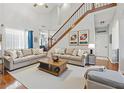 Spacious living room featuring high ceilings, hardwood floors, a staircase, and neutral décor at 4497 Black Water Cv, Ellenwood, GA 30294