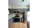 Stainless steel appliances and gray cabinets in this kitchen at 894 Glynn Oaks Dr, Clarkston, GA 30021