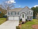 Charming two-story home with a well-maintained lawn, two-car garage, green shutters, and a welcoming front porch at 1379 Paddocks Way, Powder Springs, GA 30127