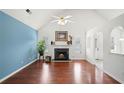 Inviting living room with hardwood floors, a cozy fireplace, and vaulted ceilings with ample natural light at 1379 Paddocks Way, Powder Springs, GA 30127