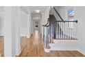 Bright foyer featuring hardwood floors, staircase, and white trim at 4974 Dovecote Trl, Suwanee, GA 30024