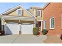 Two-car garage with attached storage and a walkway to the front entrance at 4974 Dovecote Trl, Suwanee, GA 30024