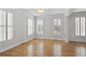 Well-lit living room with hardwood floors, white trim, and multiple windows at 4974 Dovecote Trl, Suwanee, GA 30024