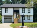 Recently updated two-story house, featuring white exterior and a gray garage at 114 Jousters Ln, Lawrenceville, GA 30044