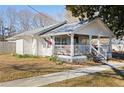 White cottage with a wraparound porch and American flag at 3170 New Macland Rd, Powder Springs, GA 30127