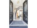 Bright and spacious entryway with a grand staircase and intricate metalwork at 3000 Leeds Garden Ln, Alpharetta, GA 30022