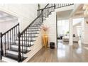 Impressive black staircase with a metal railing in a bright entryway at 3000 Leeds Garden Ln, Alpharetta, GA 30022