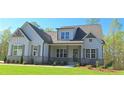Beautiful home with gray siding, brick foundation, symmetrical windows and an inviting front porch at 4515 Aiden Way, Cumming, GA 30041