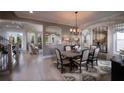Elegant dining room with brick accent wall, decorative lighting, and neutral color palette at 11360 Bennett Ln, Johns Creek, GA 30097